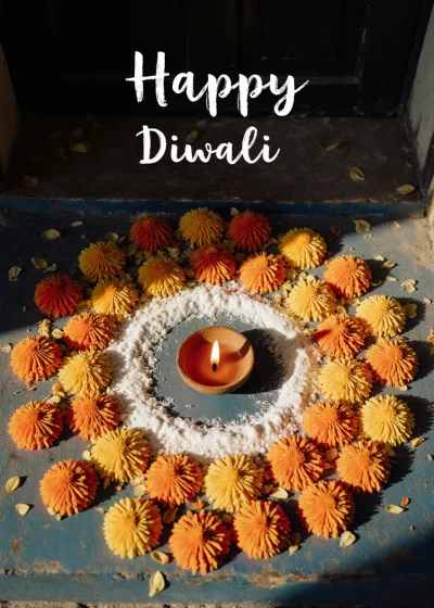 A marigold rangoli around a lamp on a blue doorstep. Happy Diwali.