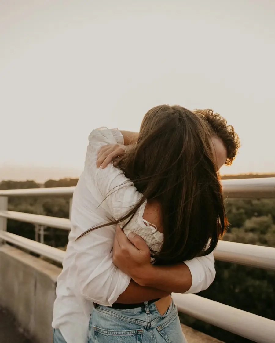Two people hugging by a railing